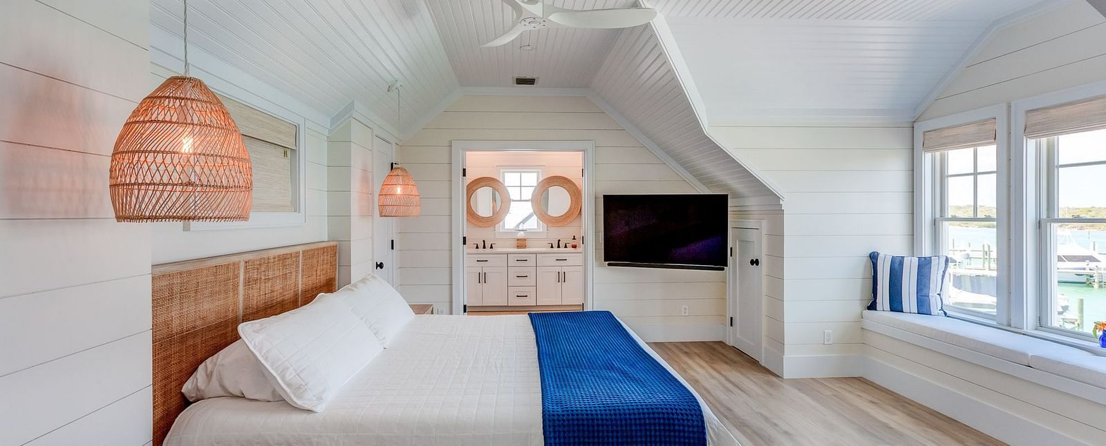 Bedroom with sloped ceiling, wooden furniture, and a TV | Abaco Inn