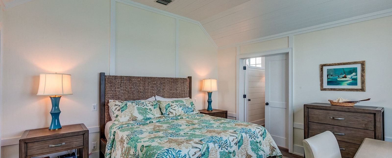 Bedroom with a patterned bedspread, wooden furniture, and a ceiling fan | Abaco Inn