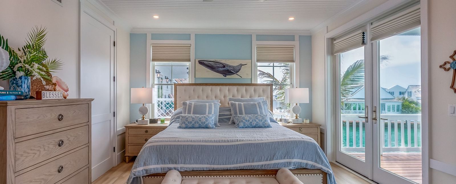 A bright and spacious bedroom with a huge bed and a sofa in the front, a cupboard, bedside table and glass doors that leads to the balcony with a sea view at Abaco Inn.