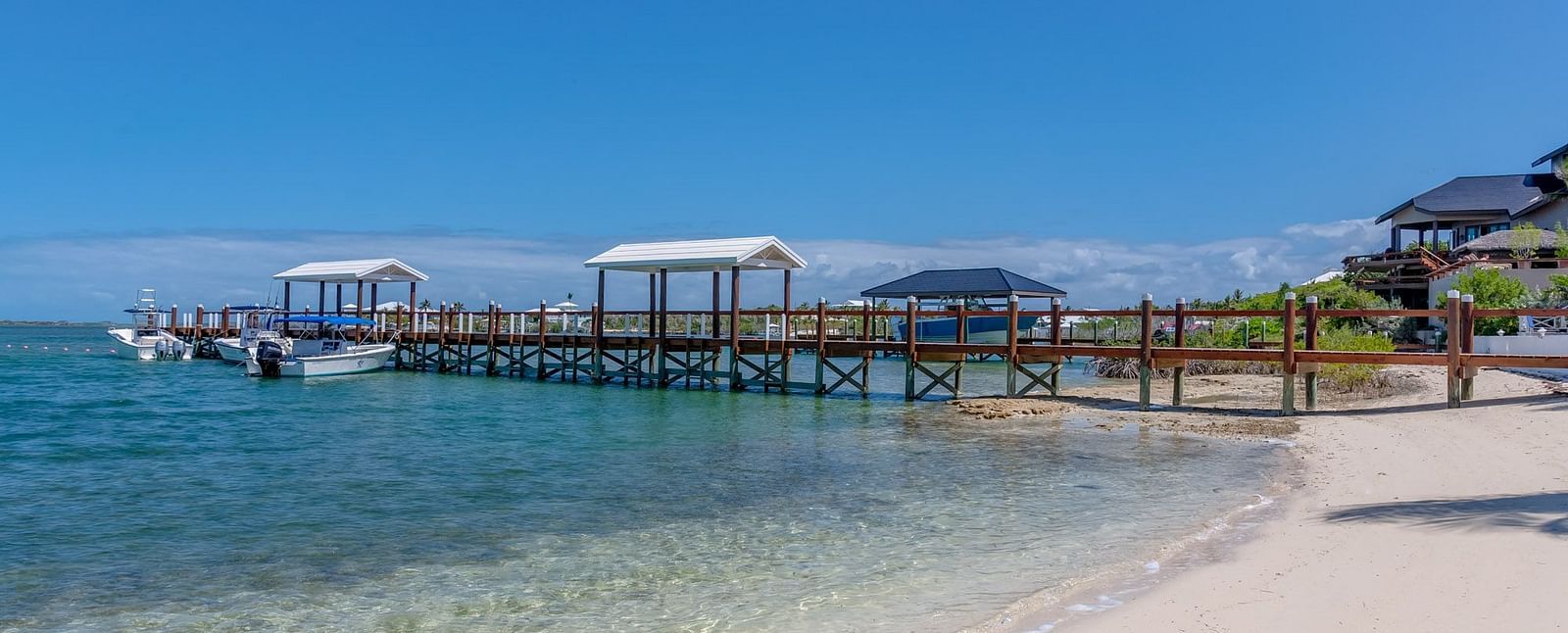 Shoreline with villas and docked boats across the bay | Abaco Inn