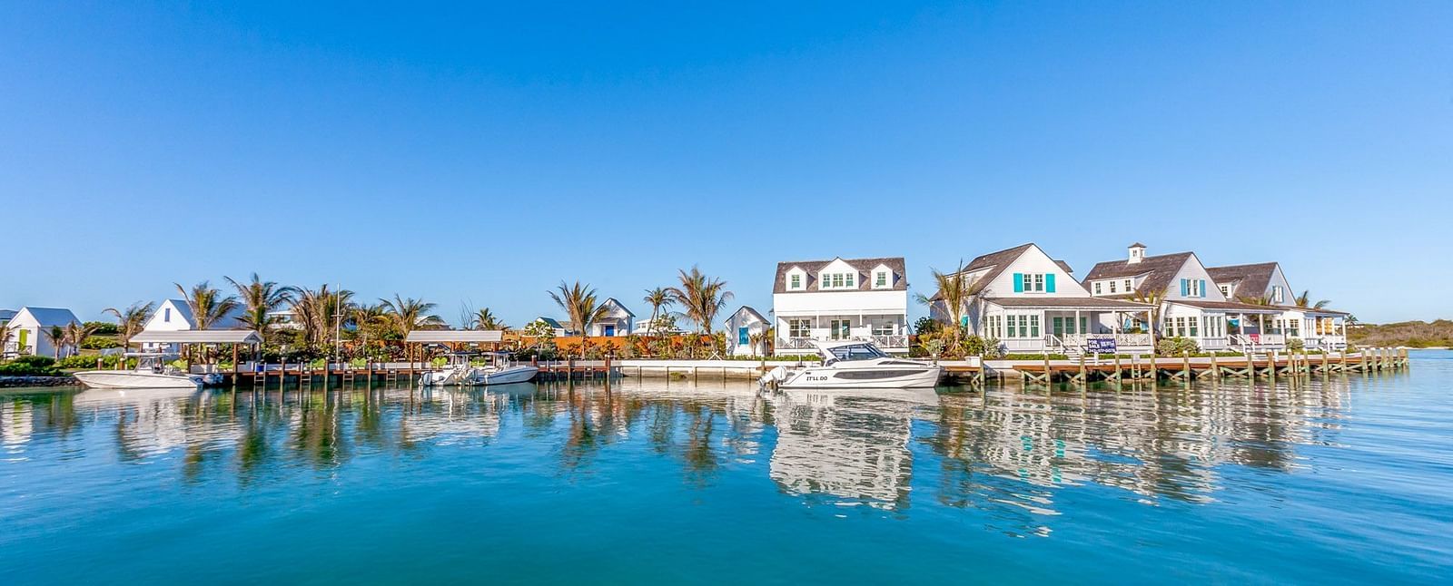 Calm water with villas and palm trees on the opposite side | Abaco Inn