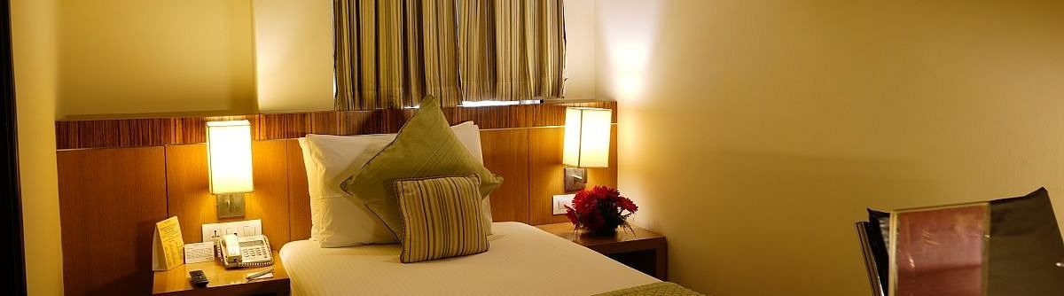 A comfy room with warm light and single bed.