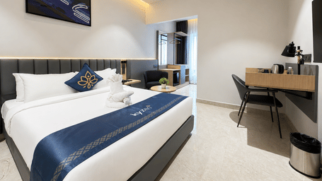 Business Room with a queen size bed, wall mounted television and work desk at Hotel Kyzen, Shamshabad Airport, Hyderabad.