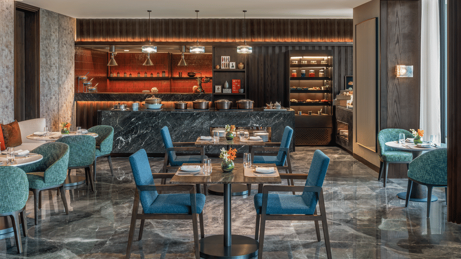 Executive Lounge with a bar counter, teal chairs and marble flooring at The Residency Signature Madurai.