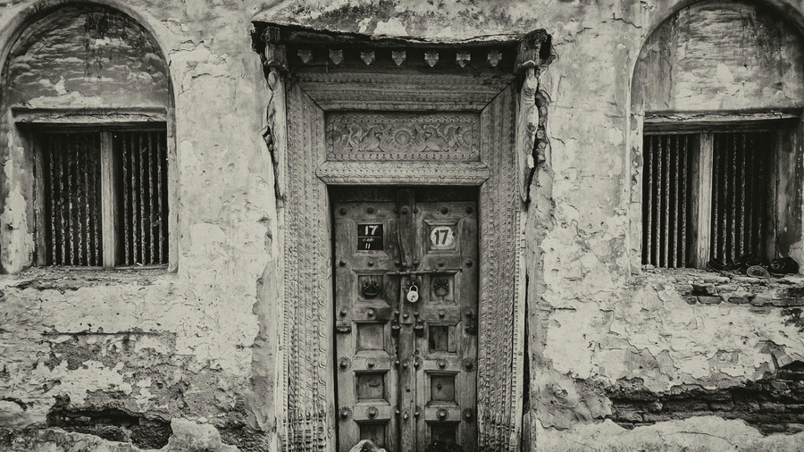An old, dilapidated building with two arched doorways and weathered walls.