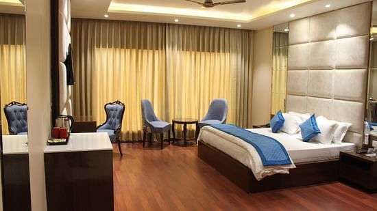 View of Deluxe room with bed and bedside tables seating area with windows and curtains  - Mastiff Hotel, Dalhousie
