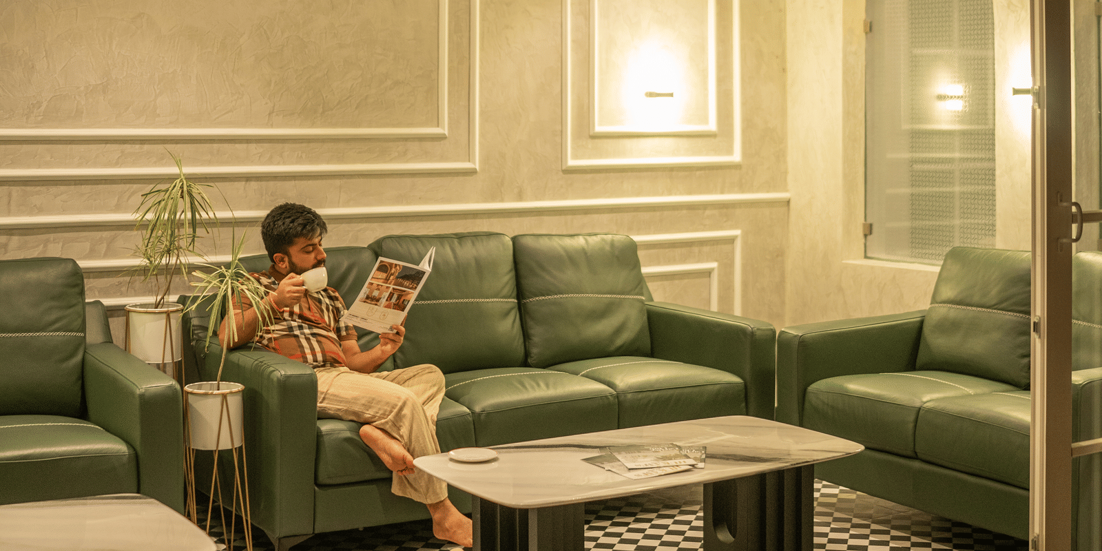 Crimson cafe interior with a person seated, featuring warm lighting and a checkered floor at Hotel Hukam's Lalit Mahal.
