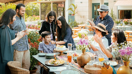 Group of people standing and talking around an outdoor table at Karma Chalets.