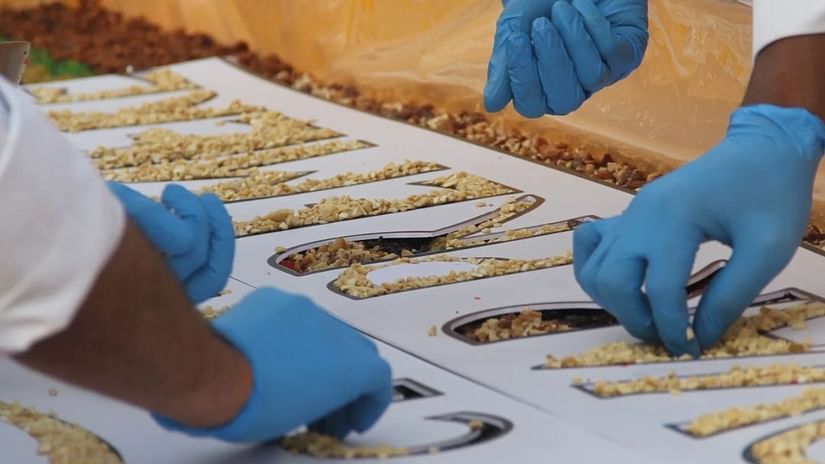 A closeup image of chefs placing dry fruits in a cake in a cake mixing ceremony - Cloud9 Sarovar Premiere, Palolem Goa