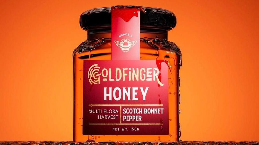 A close up shot of a red coloured bottle filled with honey and a sticker representing the name of the gift shop - Hotel 39, Jamaica