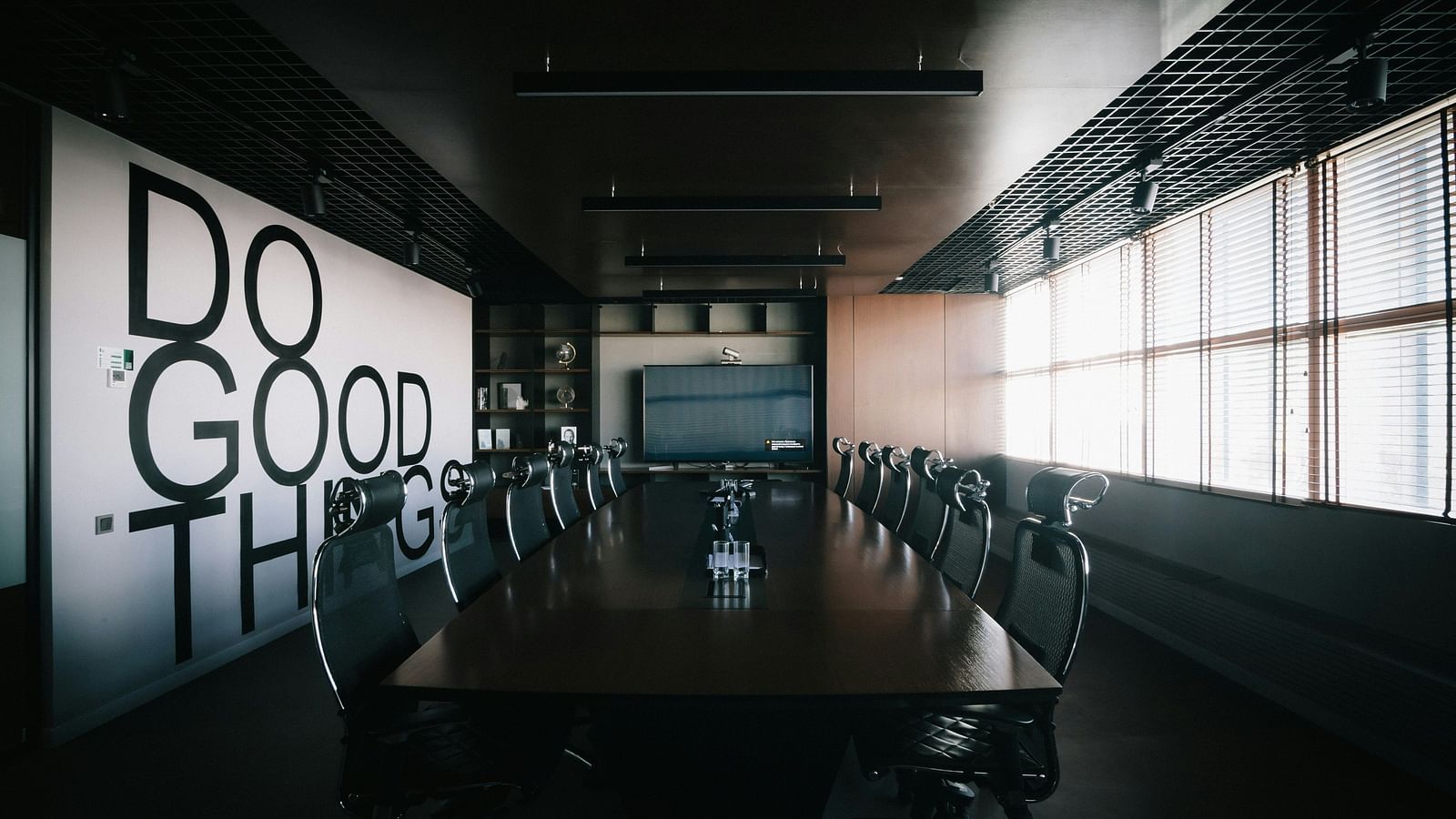A stylish boardroom with a text displayed on the wall.