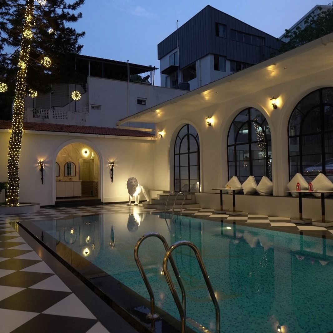 Poolside seating area with ambient evening lighting and classic architecture