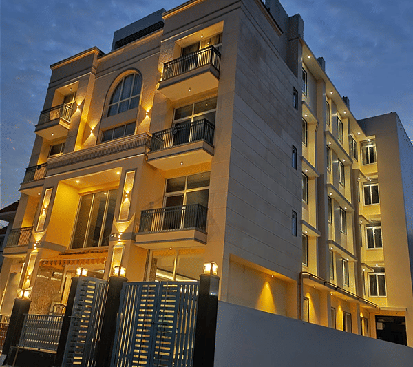 Exterior view of Lime Tree Hotel Near India Expo Mart, Greater Noida illuminated during evening.