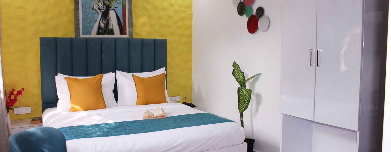 A king size bed with a painting in the background of a Deluxe Cottage Room at Royale Amata - By the Beach.
