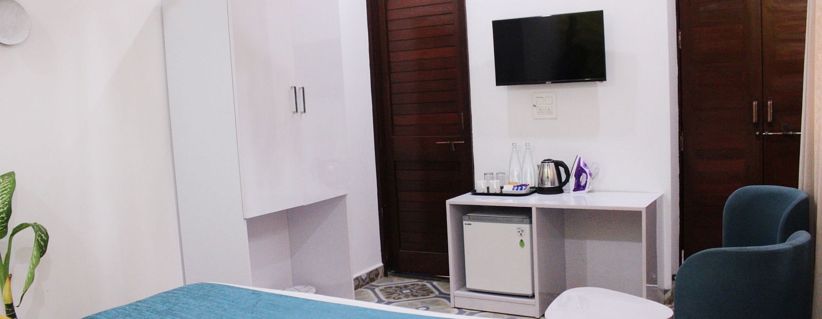 A king size bed placed in front of TV of a Deluxe Cottage Room at Royale Amata - By the Beach.