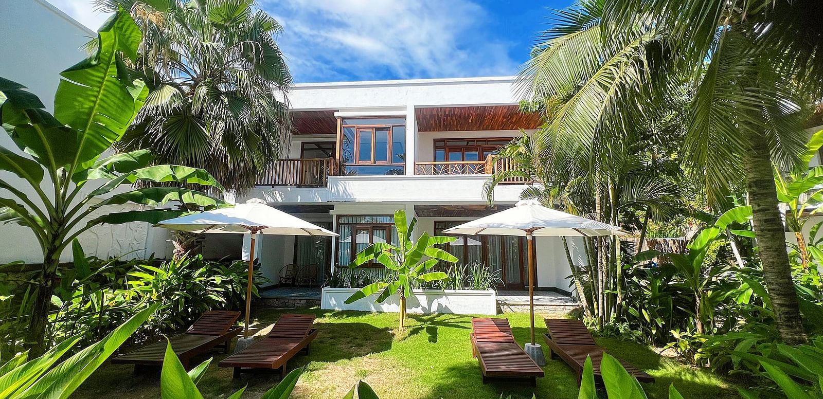 A serene view of one of our accommodations covered in lush greenery seen on a sunny day - Alibu Resorts Nha Trang