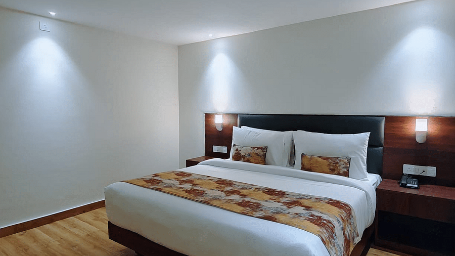 A hotel room with a bed and white lighting's providing a glimpse of the room's ambience and layout - Sumitel JB Park, Darjeeling