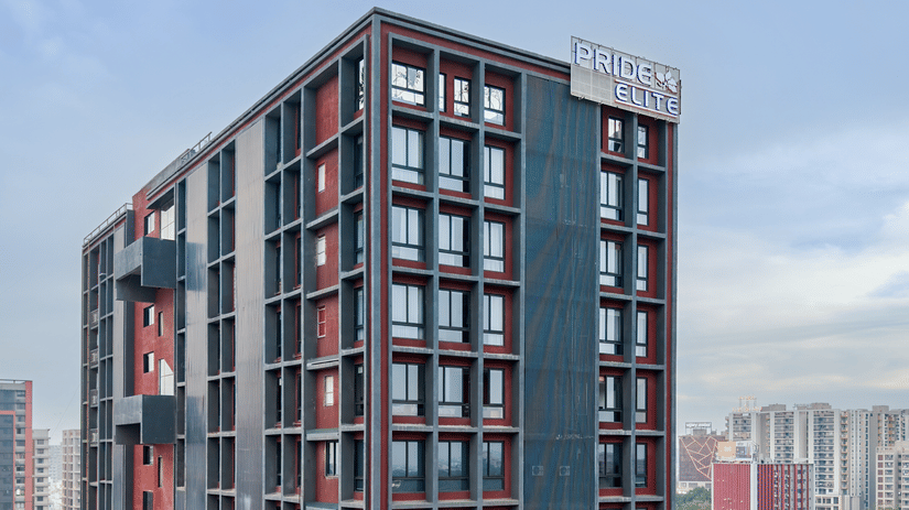Exterior view of the multi-storey hotel building along the city road - Pride Elite Gandhinagar