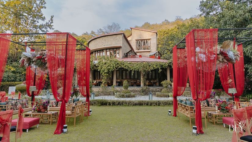 Red decorative curtains and outdoor seating for a wedding celebration