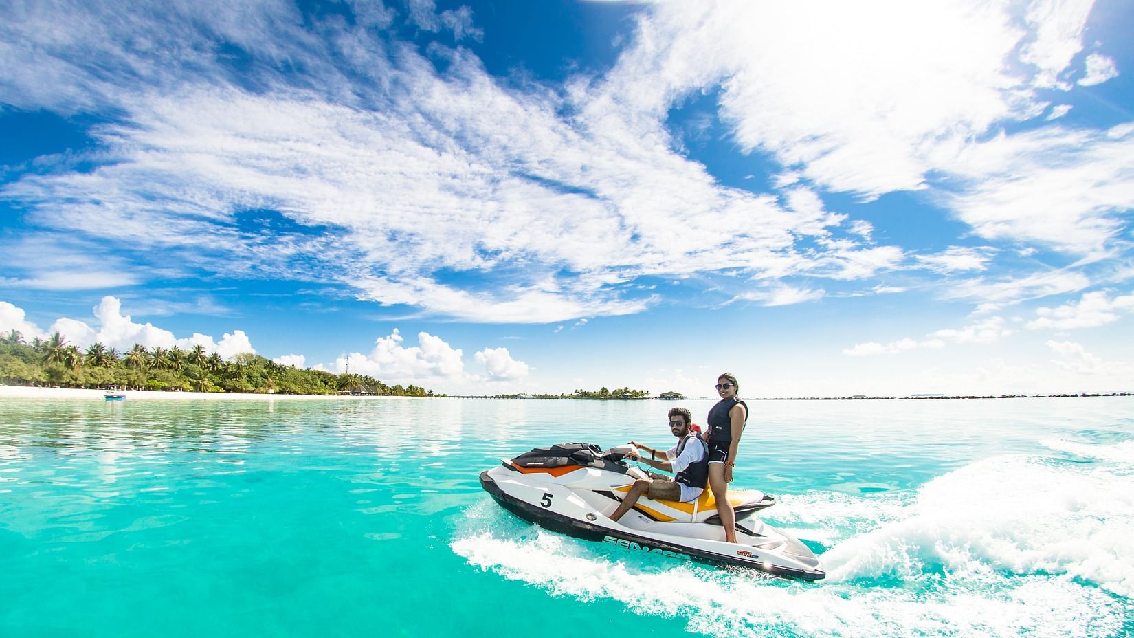 Two people jet skiing in clear blue waters
