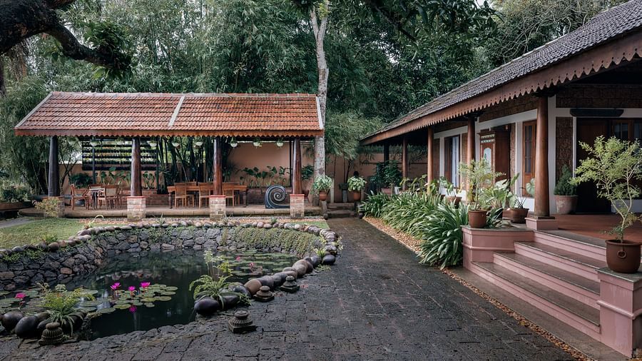 A facade of BluSalzz Villas - Muhamma Resort, Alleppey featuring the pond and the villa on the right and the restaurant in the background