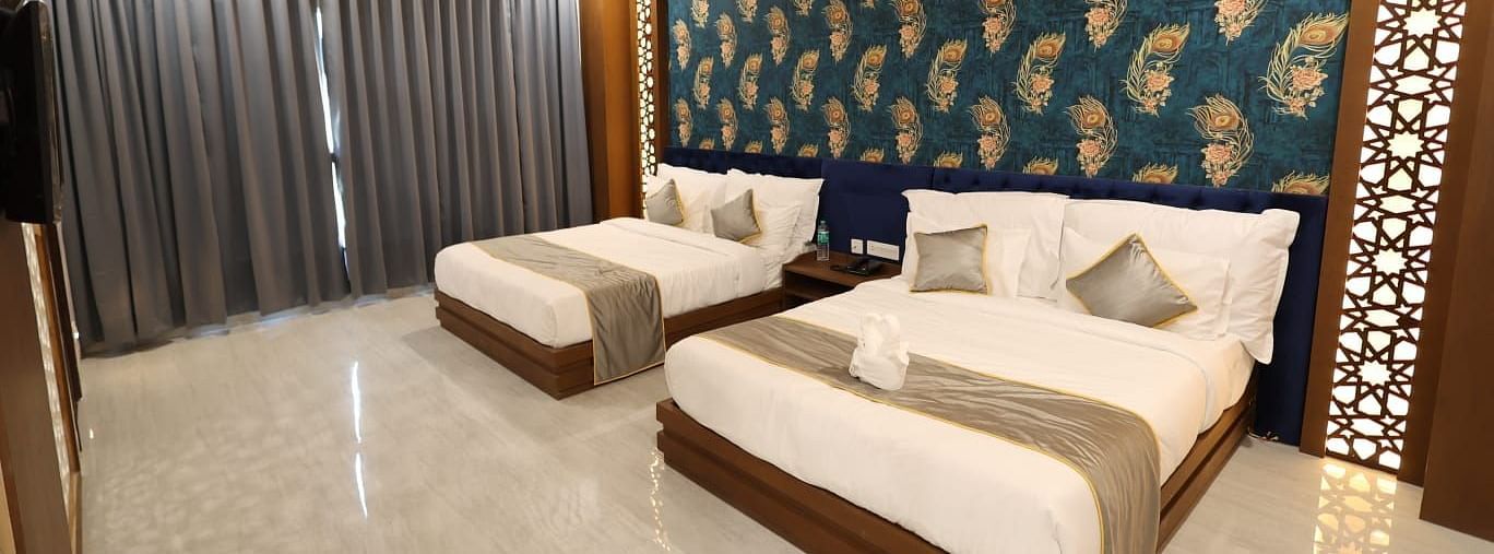 An interior shot of a room with twin beds and a textured accent wall - Bamboo Saa Mulberry Resort, Pushkar