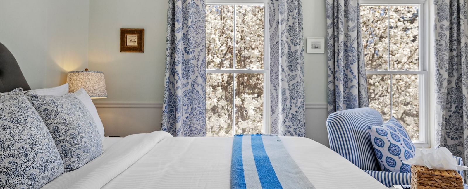A Room with blue patterned drapes and a seating area in the corner at Hartstone Inn