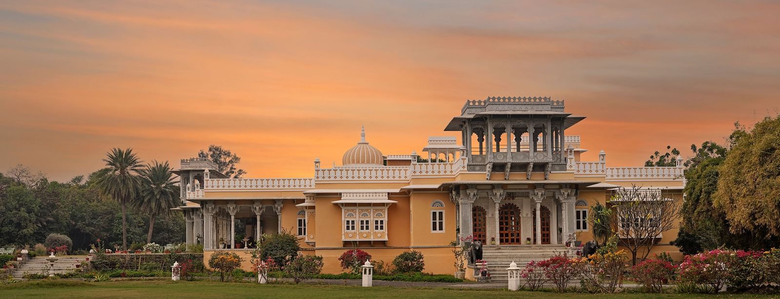 Facade image of dev shree, deogarh with a beautiful sunset sky with orange hues in the background