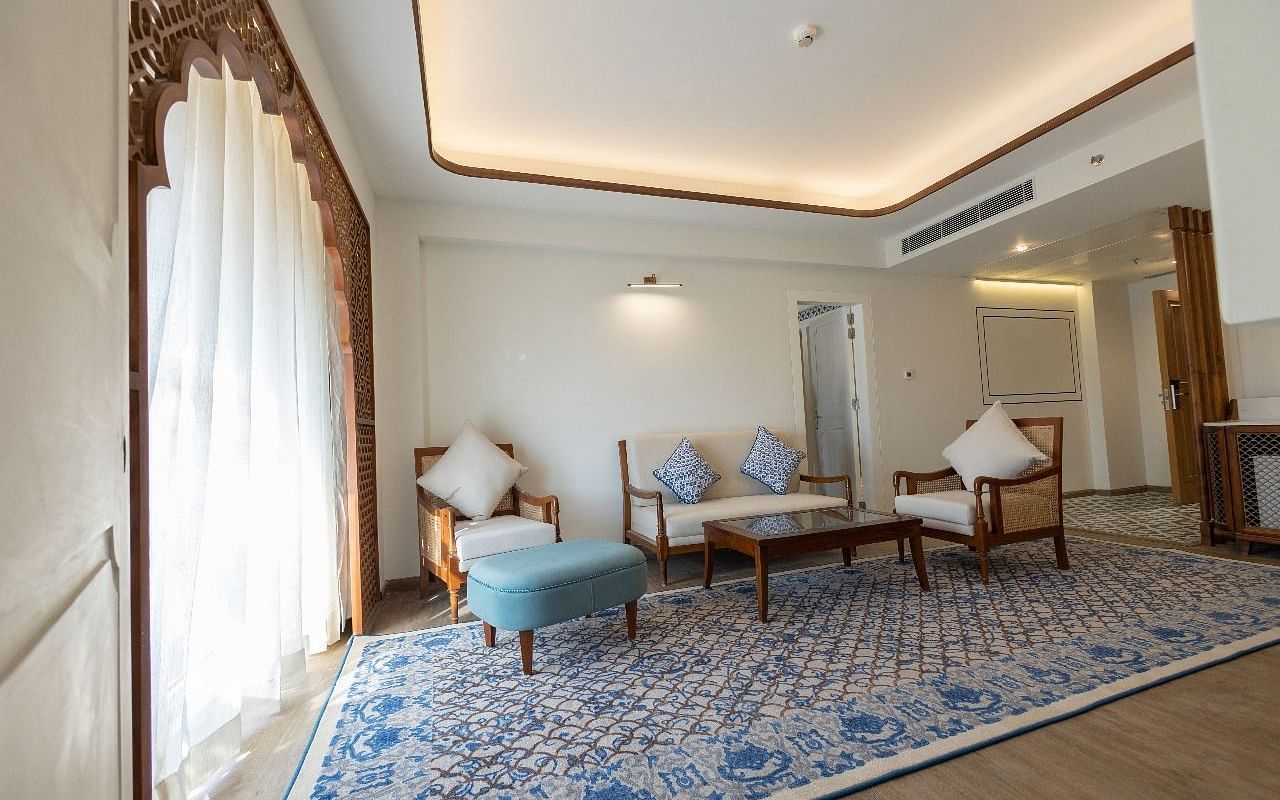 Natural light coming from the arched balcony covered with white linen curtains in the living area of the Ananta at Bhagirathi by RDB Atishay.