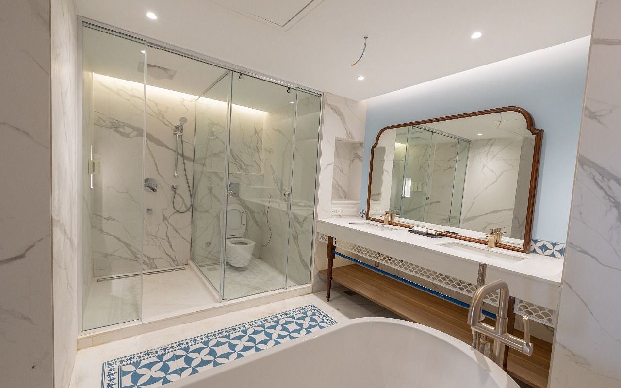 Full view shot of the luxurious bathroom with a fully stocked vanity area and a bathtub at Bhagirathi by RDB Atishay.