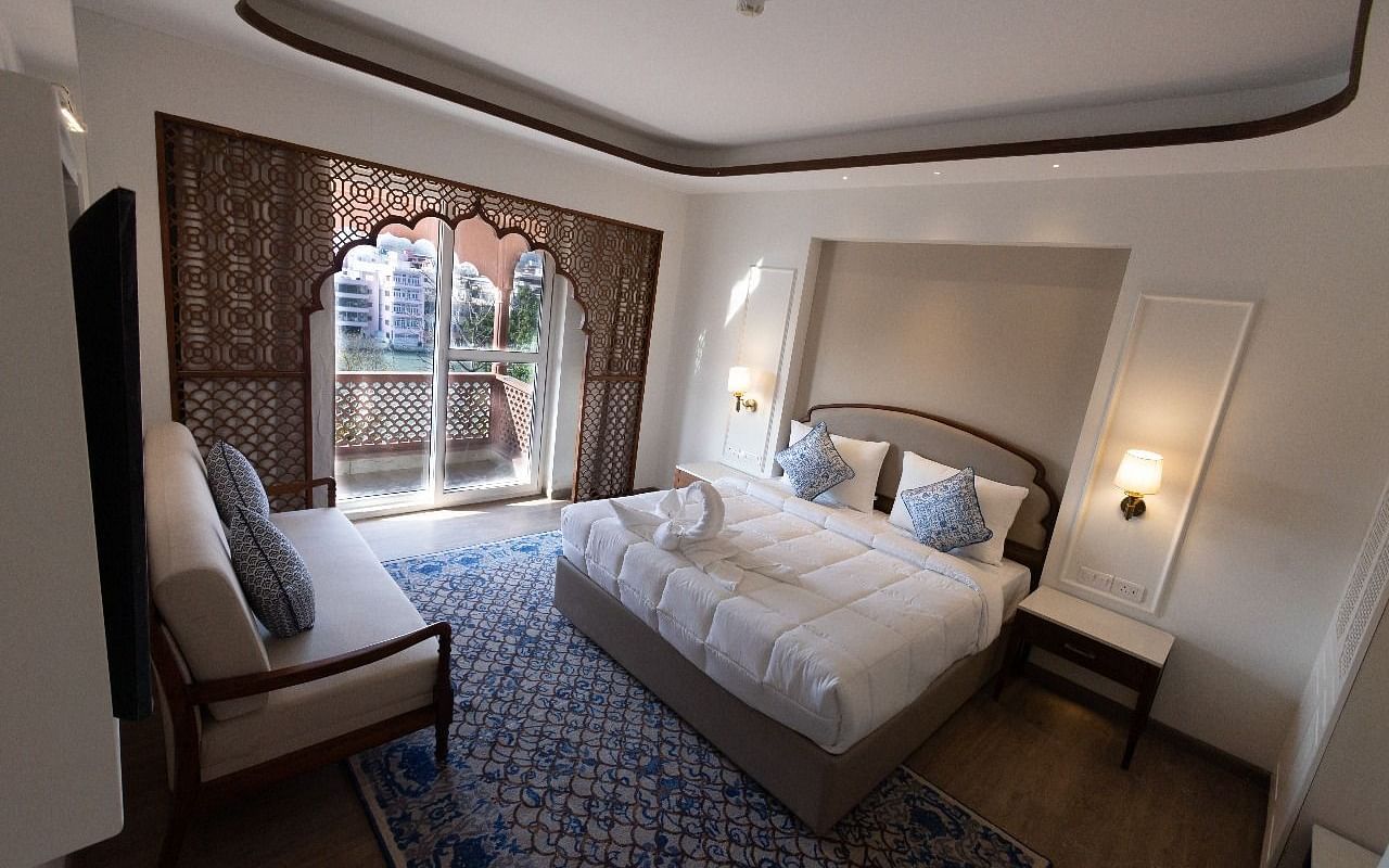 Top view shot of the Jalrupa Room featuring a double bed and a small balcony with huge french windows at Bhagirathi by RDB Atishay.