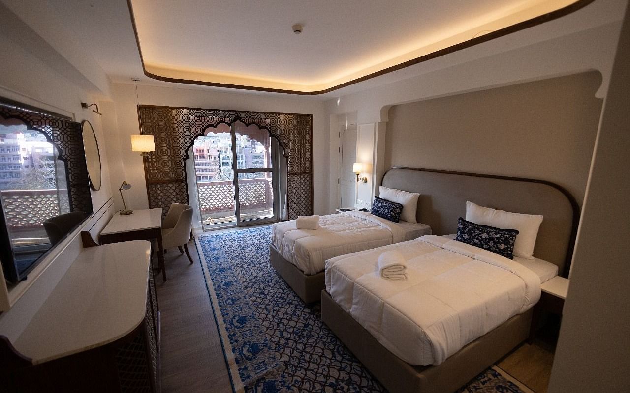 Full view shot of the Jalrupa Room with two comfortable single beds with a false ceiling at Bhagirathi by RDB Atishay.