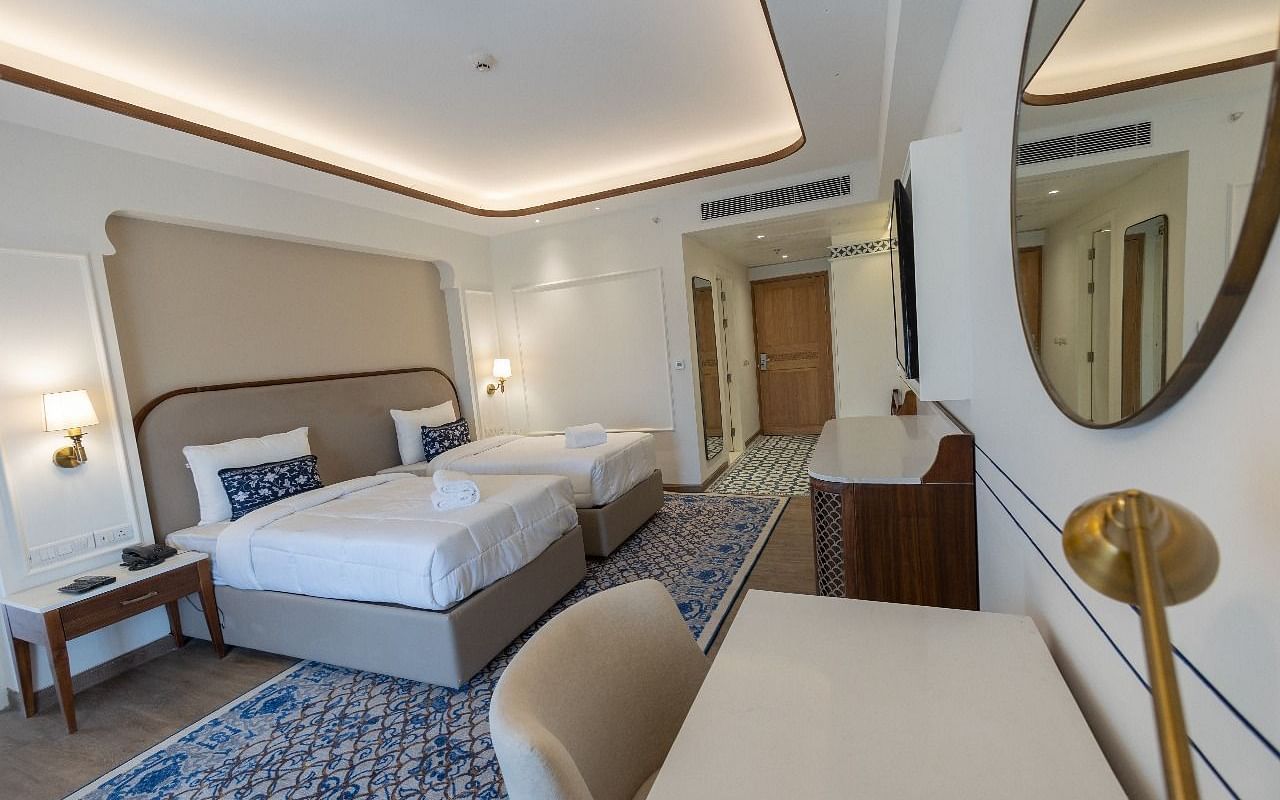 Corner view shot of the Jalrupa room with two single beds along with a work station in the foreground at Bhagirathi by RDB Atishay.