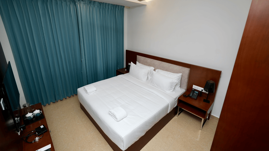 A Family Suite bedroom at Le Royale Palace with a comfortable double bed, bedside tables, and soothing lighting