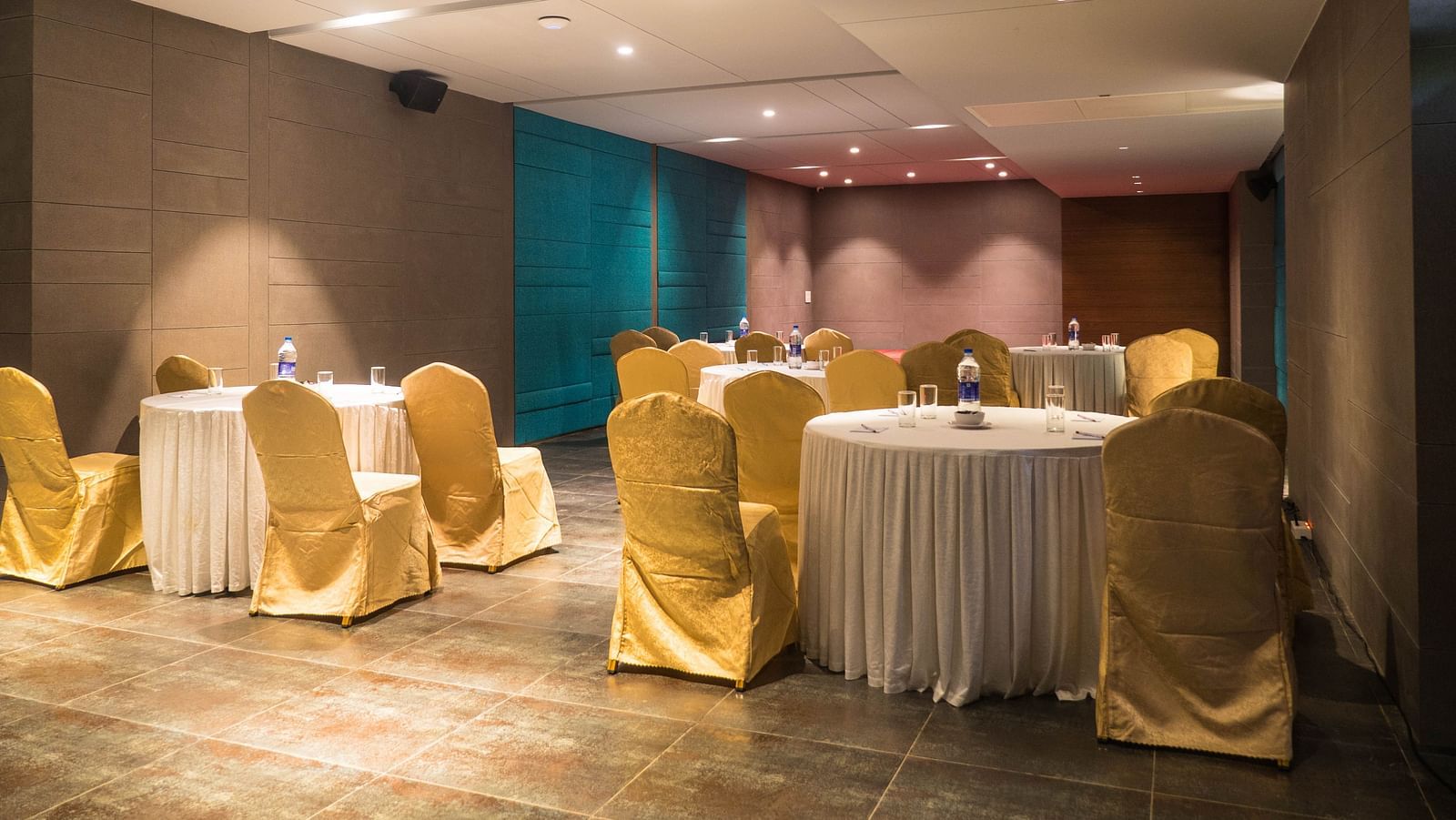 event halls with yellow chairs and white table at Cholaa Dynasty, Kumbakonam