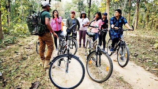 An image of a group of people standing near their bicycle