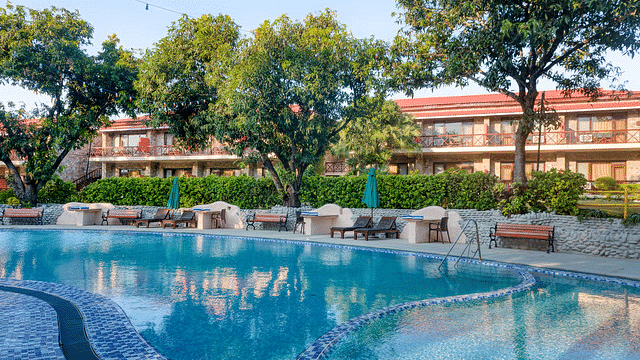 Resort pool area with clear blue water and surrounding greenery.