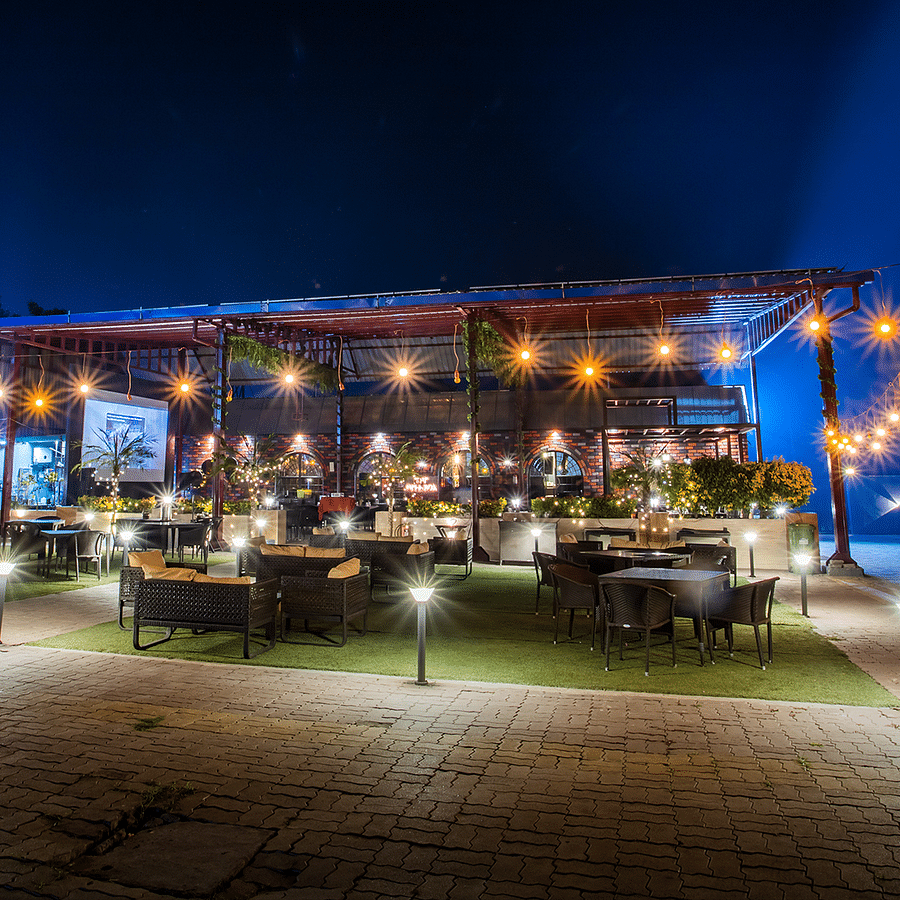 alt-text Outdoor dining setup with festive lights under a night sky