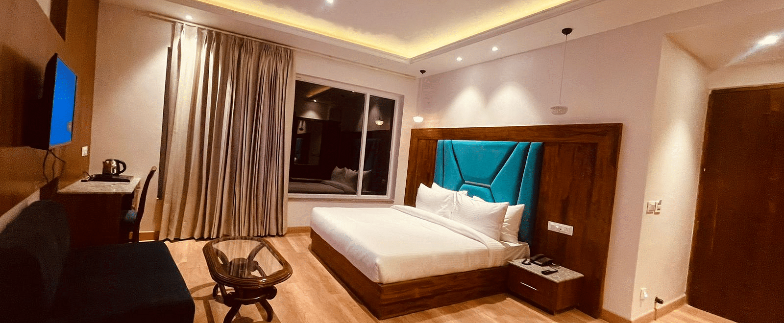 A large bed in front of the TV in Deluxe Non-view Room at DLS Ark Holiday Inn, Banikhet.