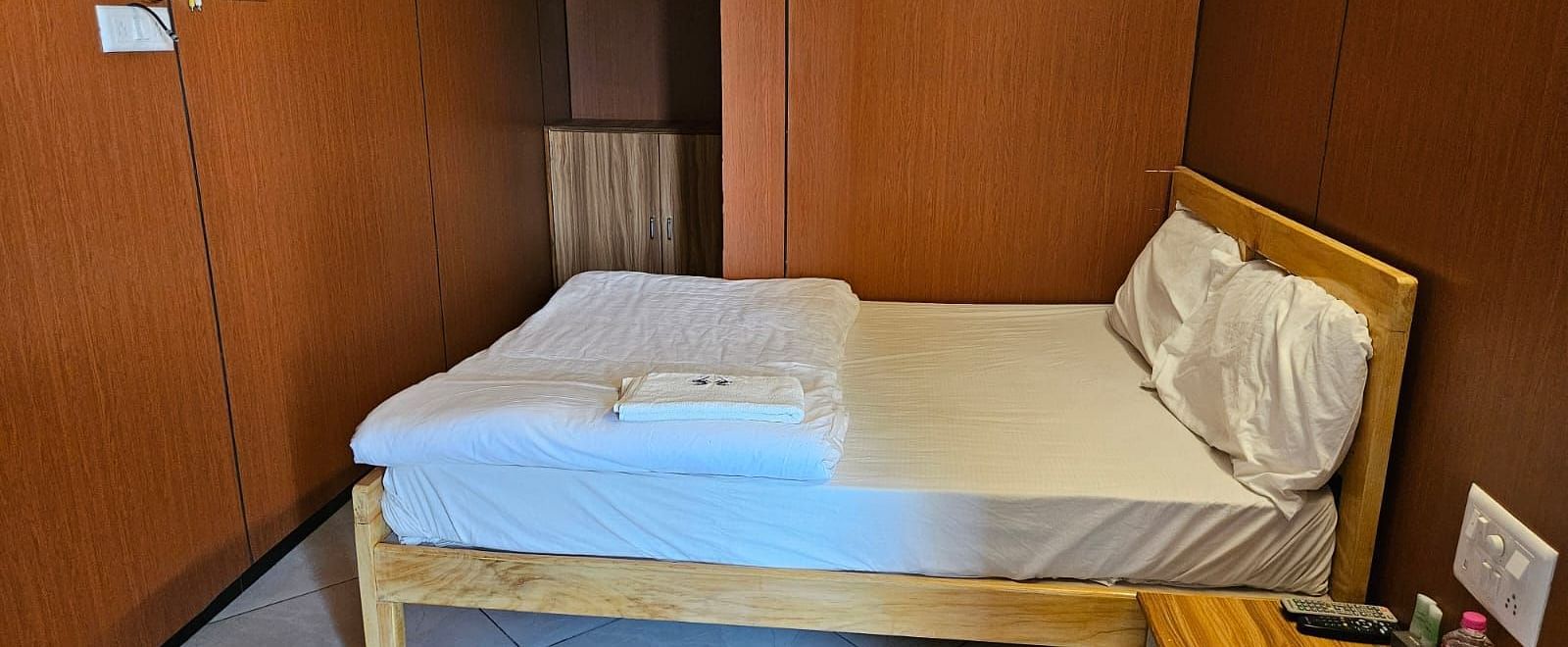 Side angle view of a room featuring a double bed alongside a bedside table at the Dream Vision Guest House.