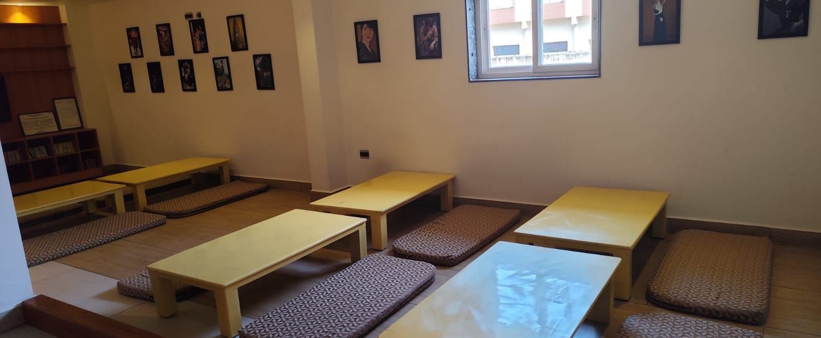 Side view of the floor seating arrangement featuring a small window emitting natural light through it at Ilara Hotels & Spa, Tada.