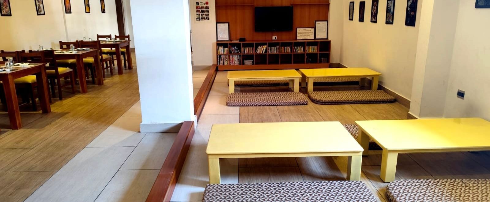 Seating arrangement on the floor at Ajito restaurant with pale yellow coloured tables surrounded with cushioned mattresses at Ilara Hotels & Spa, Tada.