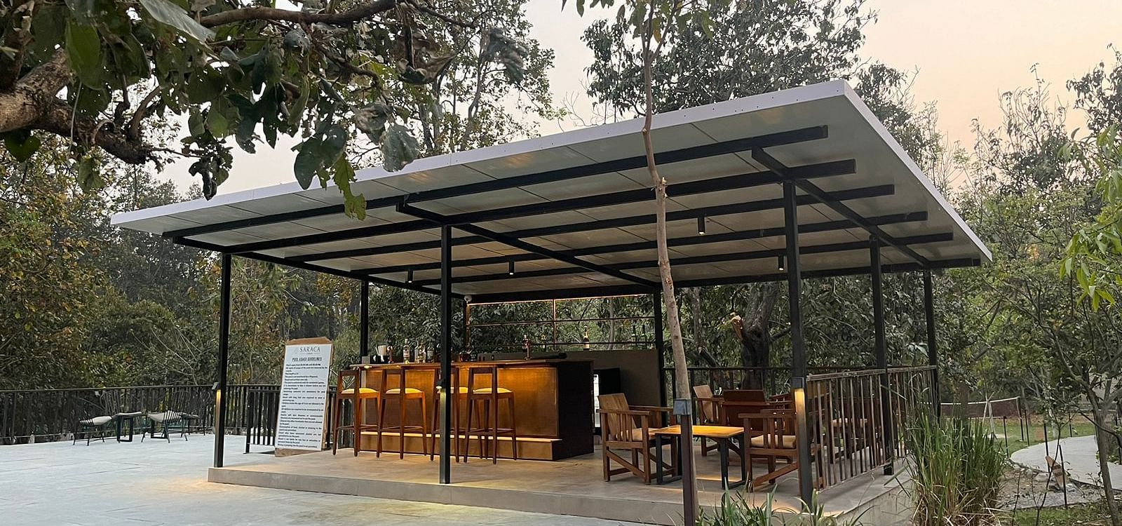 Outdoor dining arrangement amidst the garden at Saraca Resort & Spa Corbett