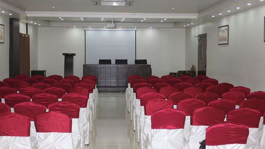 Image of Swathi Hallwith chairs arranged and lights on the ceiling at Hotel Green Apple