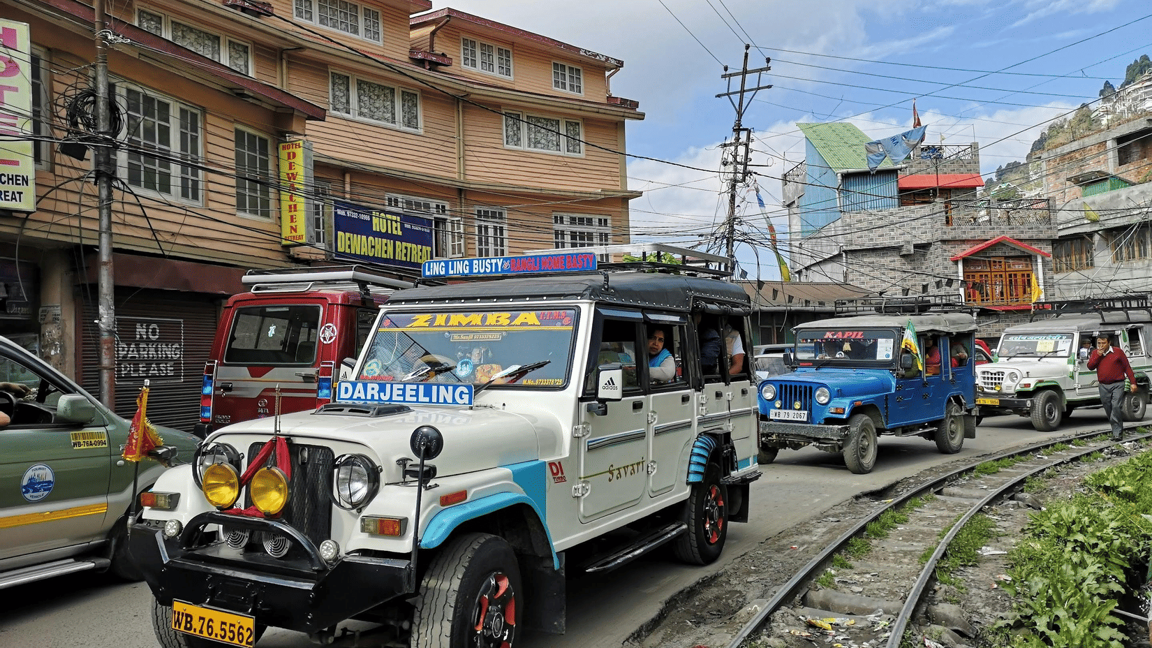Colourful shared jeeps navigating the narrow hill roads of Darjeeling, showcasing local transport and everyday mountain travel.