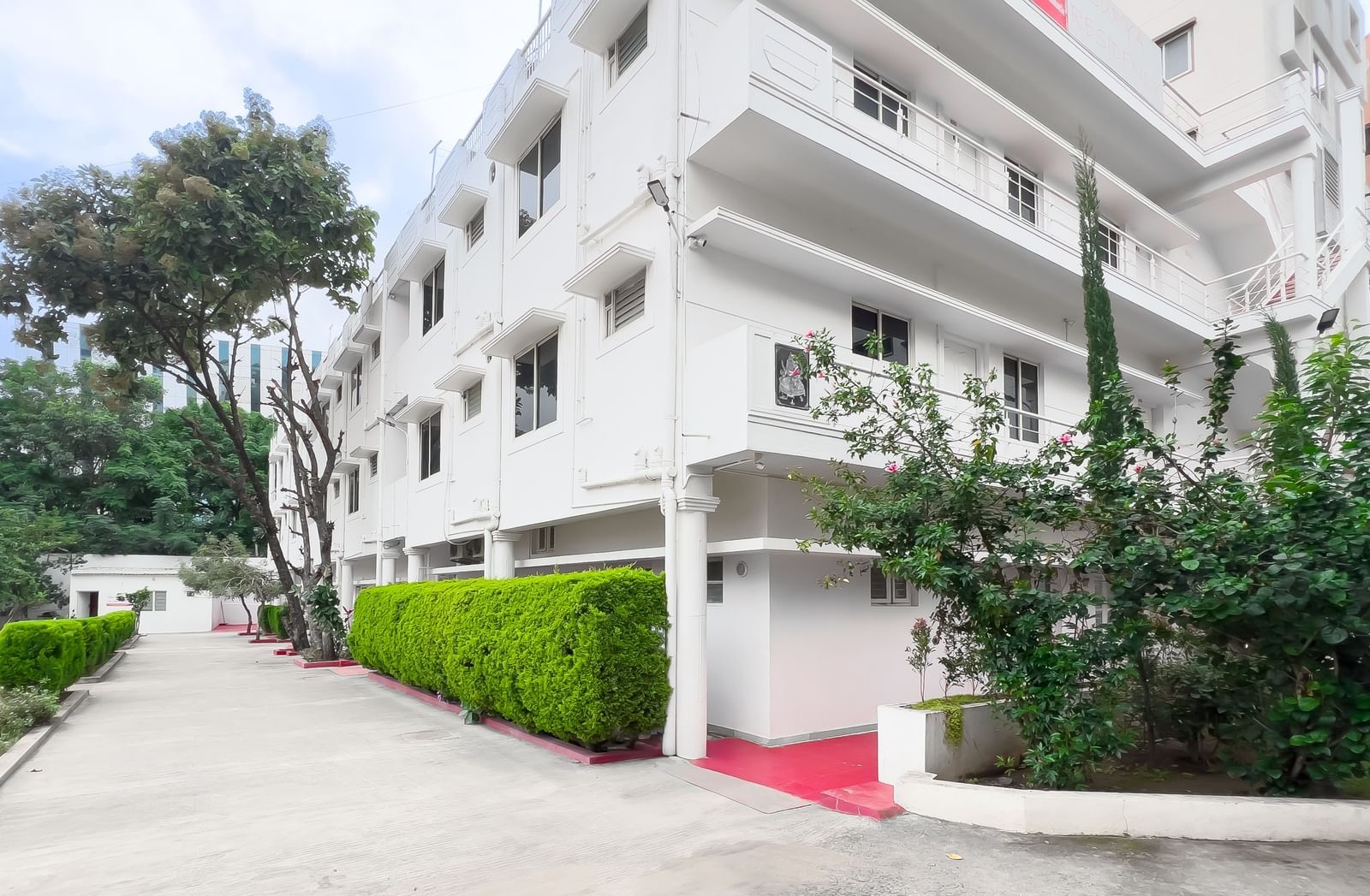 Front view of residential building with pathway and plants at The Pinnacle, Electronic City.
