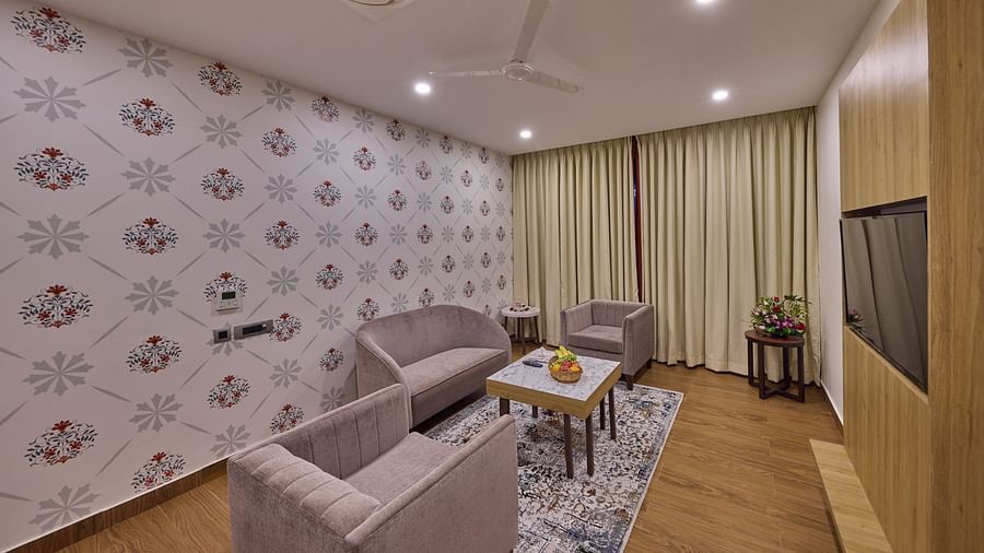 view of the living room offered at the suite decked with sofa sets and a table - Golden Tulip, Tirupati