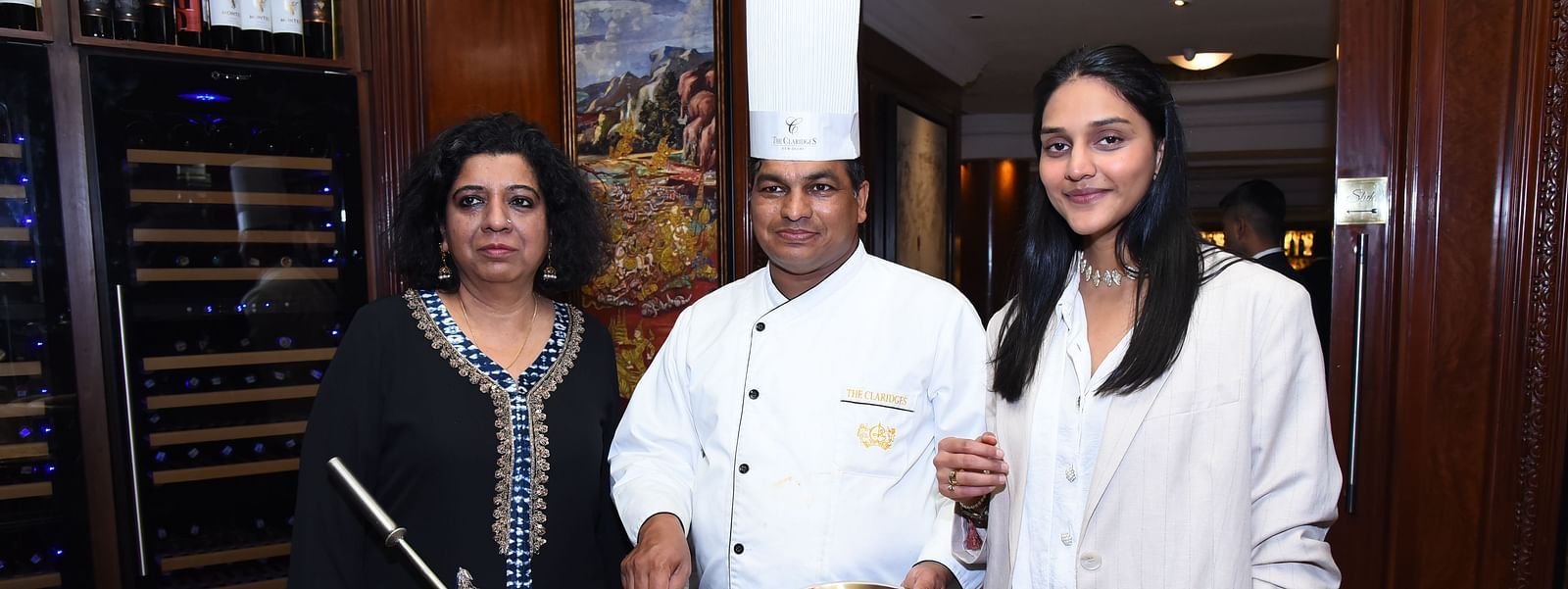 Chef Asma with other two individuals behind a pot of biryani at the The Claridges New Delhi - Claridges Collection