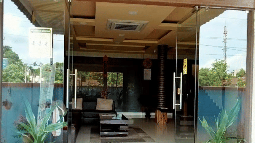 A welcoming hotel entrance with glass doors, greenery, and a warm inviting feel at Pemaling Lords Eco Inn Guwahati.