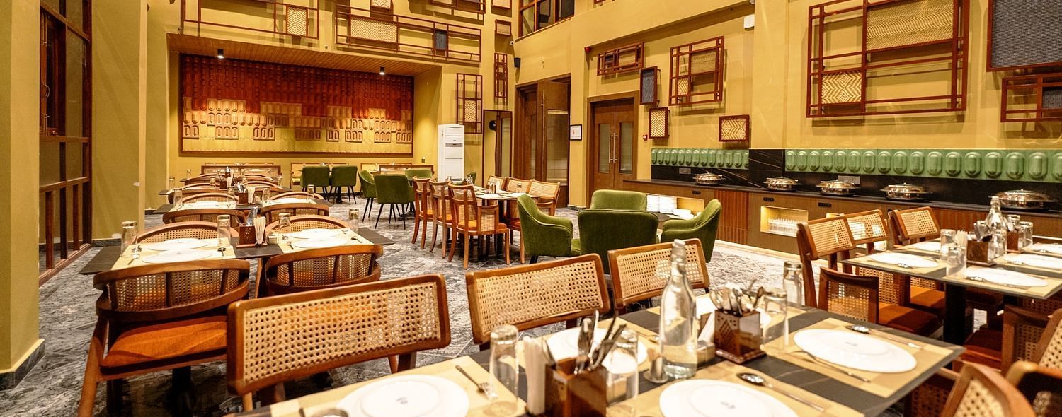A well-lit restaurant interior with numerous tables and chairs - Sea Hills Resort, Swaraj Dweep (Havelock)